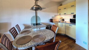 Una cocina compacta con una mesa de comedor, sillas y electrodomésticos básicos.