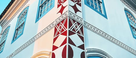 A building with a white facade and blue window frames, featuring geometric patterns and traditional architectural details.