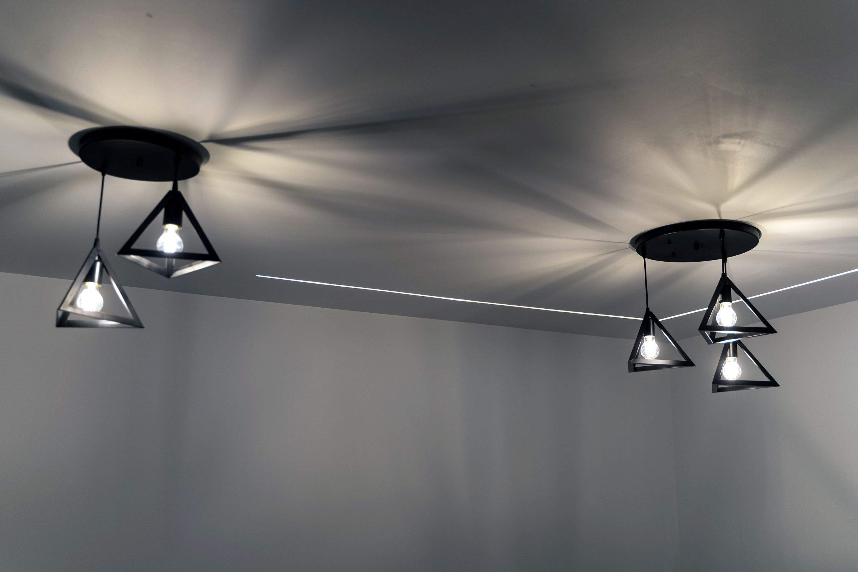 A ceiling with three pendant lights hanging from a circular fixture.