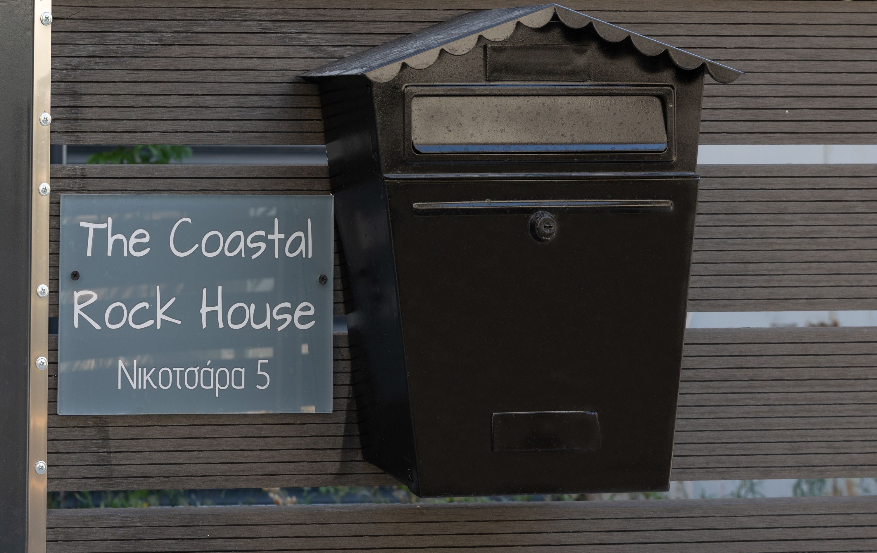 A mailbox with a sign that reads "The Coastal Rock House Nikotoppa 5".