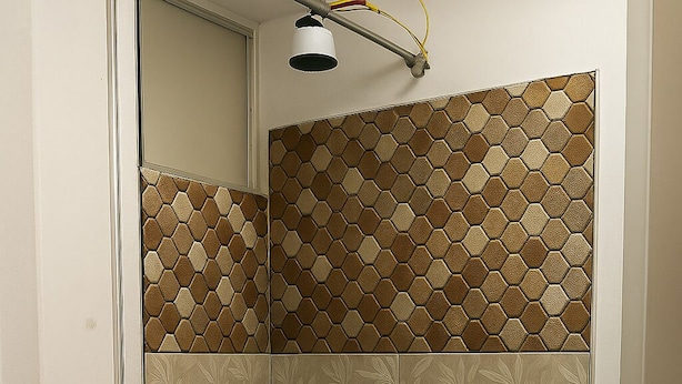 A shower with hexagonal patterned tiles, a visible drain, and a blue LED light strip along the base. - hostal kactus (Caraz)