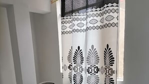 A dining area with a glass table, two chairs, and a patterned curtain. - hostal kactus (Caraz)