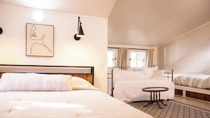 A hotel room with two beds, a small round table, and a wall-mounted lamp. - Relax by the Waterfront at The Alvig House on
Green Lake (Spicer)