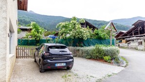 A black car parked in front of a building with a gravel driveway. - MUTCHOS - LA PLAGNE TARENTAISE (LA PLAGNE TARENTAISE)