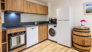 A modern kitchen with wooden cabinets, a dishwasher, a washing machine, and a refrigerator. - MUTCHOS - LA PLAGNE TARENTAISE (LA PLAGNE TARENTAISE)