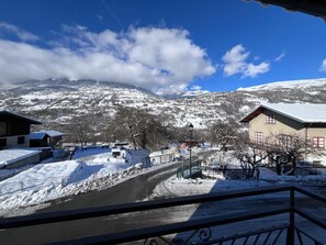 A snow-covered mountain landscape with a clear sky, a paved road, and buildings with snow on their roofs. - MUTCHOS - LA PLAGNE TARENTAISE (LA PLAGNE TARENTAISE)