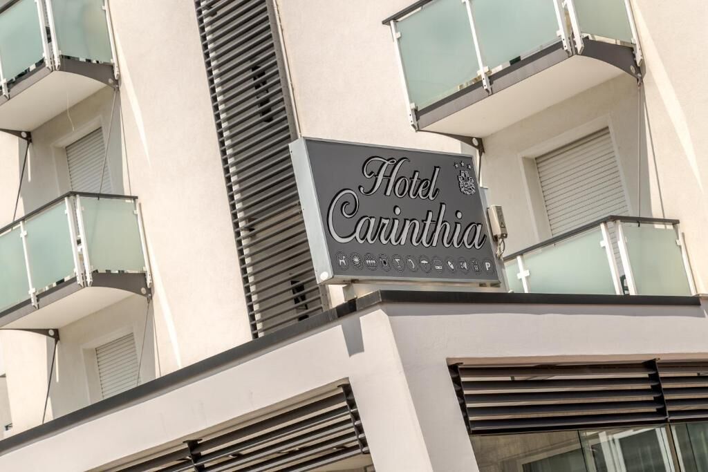 A hotel sign with the name "Hotel Carinthia" and a coat of arms.