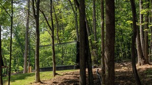 A forested area with a metal bridge and a wooden structure. - Mirrored Glass Studio · Hot Tub · Nature Views (Laurelville)
