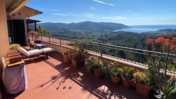 Ein Balkon mit Blick auf Berge und Meer.