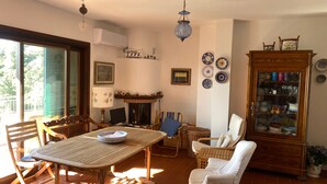 Ein Wohnzimmer mit Kamin, einem Esstisch und verschiedenen dekorativen Tellern an der Wand.