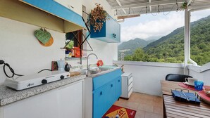 A kitchen with a view of mountains, a Mickey Mouse rug, and a blue cabinet.