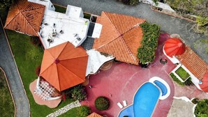 An aerial view of a resort with a swimming pool, multiple red-roofed structures, and a white building. - B&B Casa de Campo Mía, just steps from the beach! (Nueva Gorgona,)