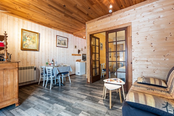 Un interior de madera con comedor, cocina y sofá.