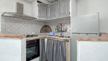 Cafetera o tetera, frigorífico, placa de cocina y utensilios de cocina
