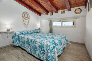 A bedroom with a bed, a dreamcatcher, a window, and a wooden ceiling. - Apartment 'Flamingo' with Private Terrace, Balcony and Air Conditioning (san teodoro)