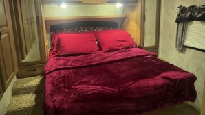 A compact bedroom with a bunk bed, a small closet, and a ceiling light. - Cozy RV in charming McClure with AC, WiFi. Happy travels (McClure)