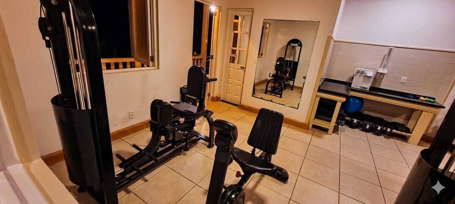 Une salle de sport à domicile équipée de matériel d’exercice, d’un miroir et d’un support à poids.