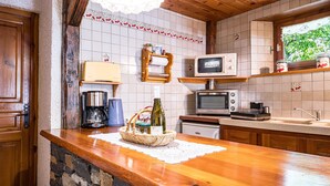 A kitchen with a wooden countertop, a coffee maker, a microwave, and a sink.