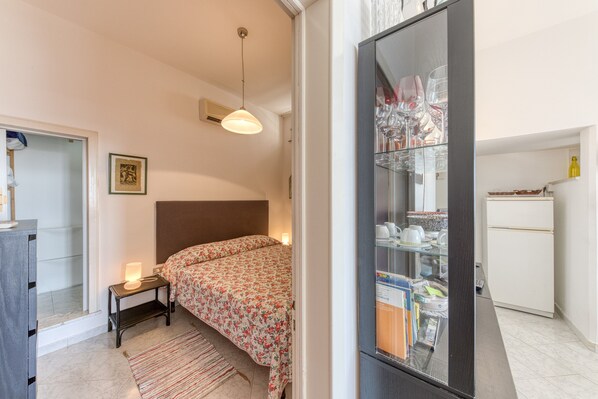 A bedroom with a bed, bedside table, lamp, and a wardrobe with a mirror. - Holiday Home 'Emilia' with Sea View, Wi-Fi and Air Conditioning (Marina di Andrano)