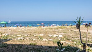 A beach with people, umbrellas, and a scooter. - Holiday Home 'Piazzetta Al Mare' with Sea View, Wi-Fi and Air Conditioning (Palermo)