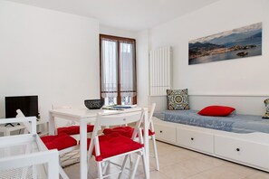 A modern room with a dining table, chairs, a sofa, and a painting of a coastal landscape. - Apartment 'Lami' with Wi-Fi (Intra)