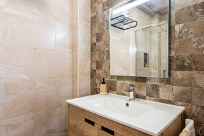 A bathroom with a white sink, a mirror, and patterned tiles. - Studio 'La Bodega' with Wi-Fi (Ademuz)