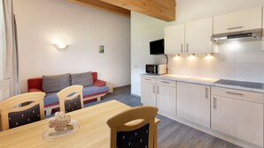 Une cuisine moderne avec des meubles en bois, un four à micro-ondes et un téléviseur.