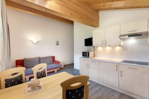 Une cuisine moderne avec des meubles en bois, un four à micro-ondes et un téléviseur.