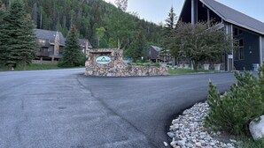A lodge with a stone welcome sign, a flag, and a mountain backdrop. - Fabulous one bedroom condo less than 5 min from Purgatory with ski shuttle stop (Durango)