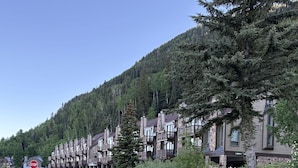 A row of multi-story buildings with balconies, set against a backdrop of a forested hillside. - Fabulous one bedroom condo less than 5 min from Purgatory with ski shuttle stop (Durango)