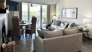 Un salon spacieux avec une cheminée, un coin repas et un balcon offrant une vue sur les environs.