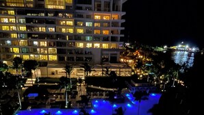 A multi-story hotel with a pool area illuminated by blue lights. - Luxury in Cancun, beautiful private residence club on the beach. (Cancún)