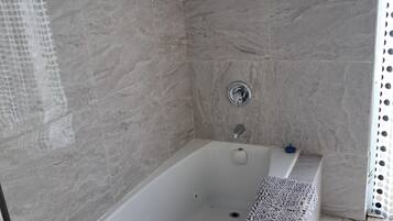 Tina de hidromasaje, toallas, jabón, papel de baño