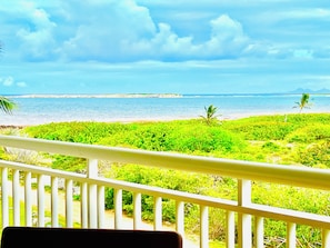 A balcony with a view of the ocean and a beach. - Waterfront. A stylish and relaxing suite in Mont Vernon, Orient Bay. Pool. Beach. View. (Saint-Martin)