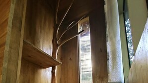 Un intérieur en bois avec une grande fenêtre, des étagères en bois et un plafond en pente.