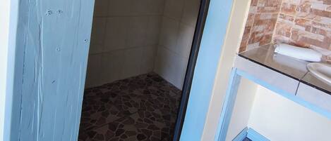 A bathroom with a shower, a window, and a towel rack.