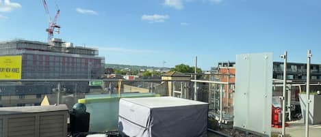 A rooftop with construction equipment, a covered area, and a view of a building under construction in the background.