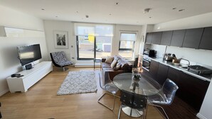 A modern apartment with a living room, dining area, and kitchen. - 2-bed Apt, Sleeps 7, 5 Mins to Camden Market (London)