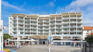 Un hôtel à plusieurs étages doté de balcons, d’une entrée couverte et offrant une vue sur le front de mer.