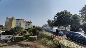 A parking lot with several cars and a building with multiple windows and balconies. - Studio Cabin 4 Pers, Cap d'Agde, Near Beach (Cap d'Agde)