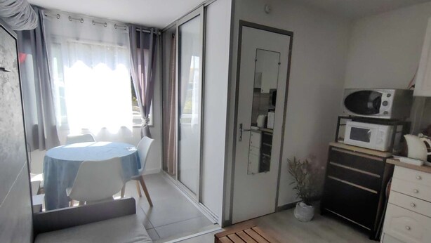 A compact living space with a dining area, kitchenette, and a small bench. - Studio Cabin 4 Pers, Cap d'Agde, Near Beach (Cap d'Agde)