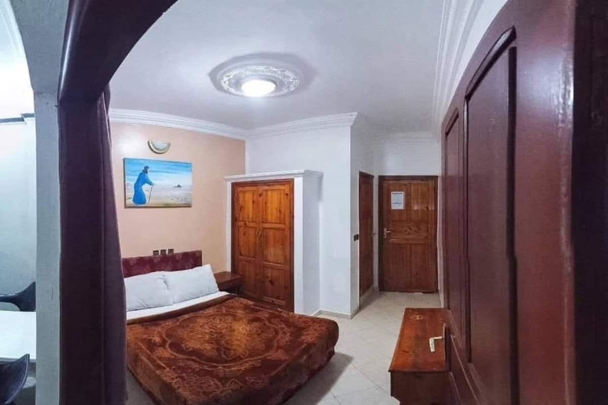 Un dormitorio con cama, escritorio y armario.
