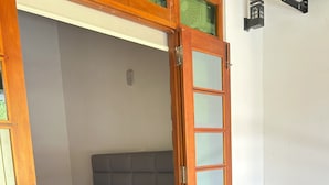 A room with a bed, a wooden table, and two chairs.