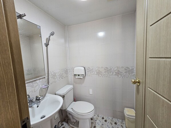 Un baño pequeño con inodoro, lavabo y ducha.