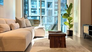 A modern living room with a sofa, a coffee table, and a potted plant. - Modern King West Condo | Central + Free Parking (Toronto)