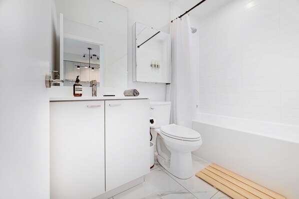 Un baño moderno con inodoro, lavabo y zona de ducha.