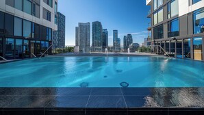 A swimming pool with a cityscape view, surrounded by modern buildings. - Modern King West Condo | Central + Free Parking (Toronto)