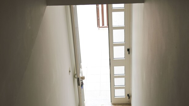 A staircase leading to a door with a view of the outside.