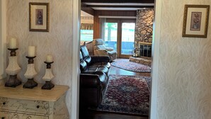 Un salon chaleureux avec une cheminée, un canapé en cuir et un tapis.