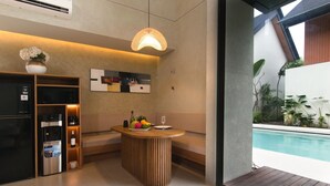 Una cocina moderna con un refrigerador empotrado, una cafetera y un frutero.
